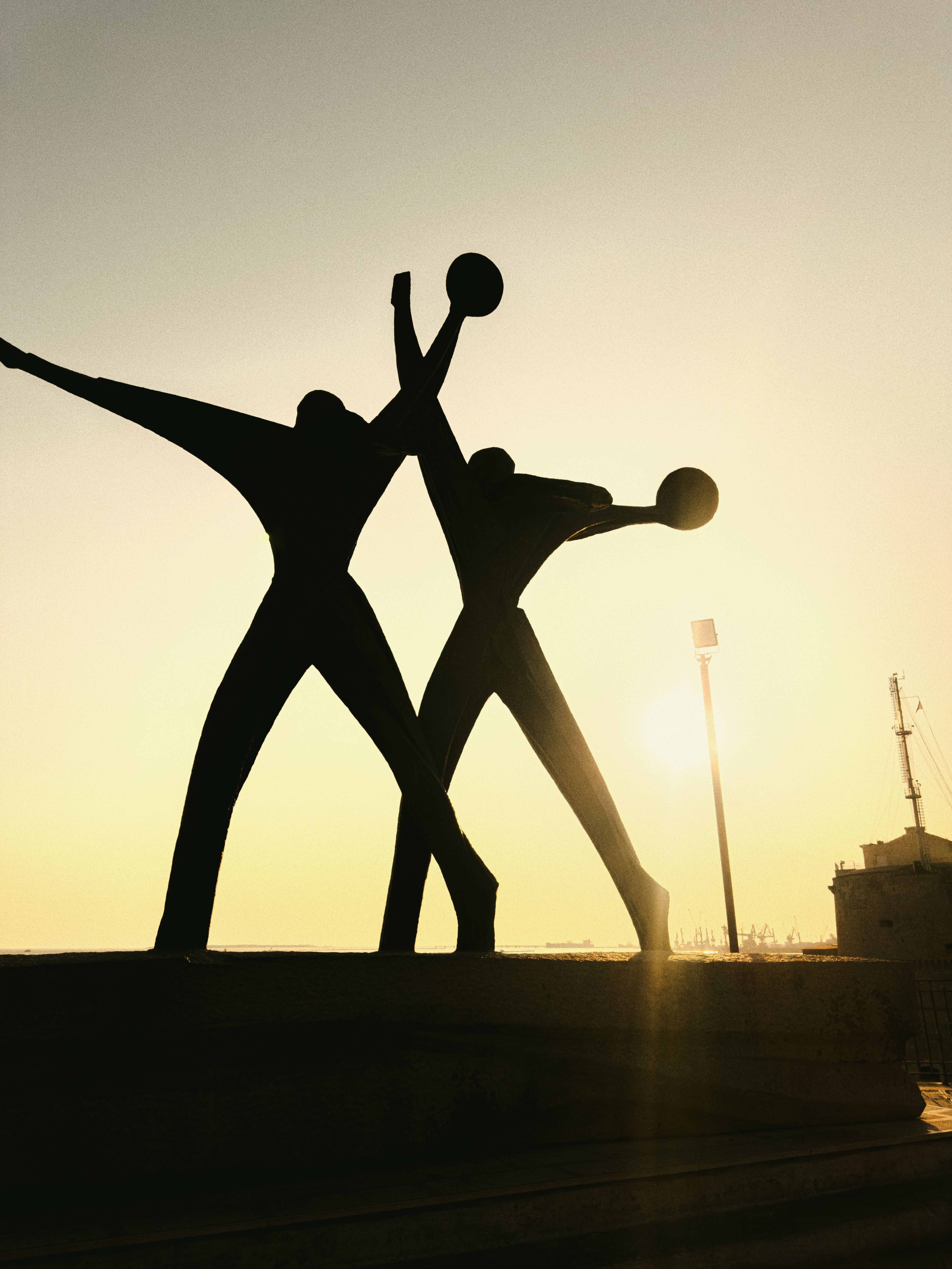 studio tributario de monte Silhouette of a modern sculpture at sunset in Taranto, Italy, capturing an artistic and dramatic mood.